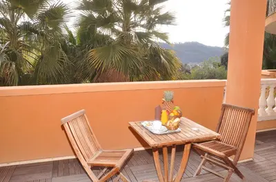 a table and two chairs on a balcony with a table with fruit at Appart Hotel Lou Castelet in Carros