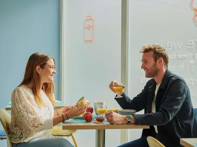 a man and woman sitting at a table drinking wine at Aparthotel Adagio Access Nice Magnan in Nice