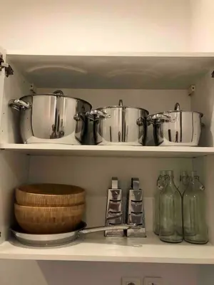 a kitchen shelf with pots and pans on it at Lovely large familial apartment in central Nice, ten minutes walk to the beach! in Nice