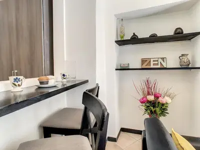 a dining room with a table and chairs and a vase of flowers at Nestor&Jeeves - ZEN - Central - Very close beaches in Nice