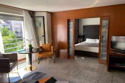 a living room with a bed and a television at Goldstar Apartments & Suites in Nice