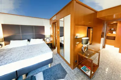 a hotel room with a large bed and a mirror at Goldstar Apartments & Suites in Nice