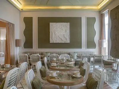 a dining room with tables and chairs and a painting at Hôtel Le Soleia by Inwood Hotels in Nice