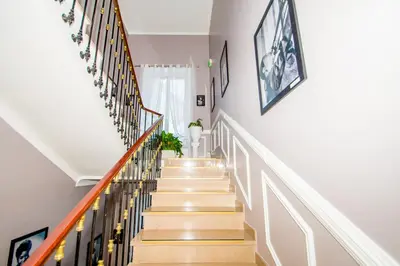 a stairway with white walls and wooden stairs at Hôtel Parisien in Nice