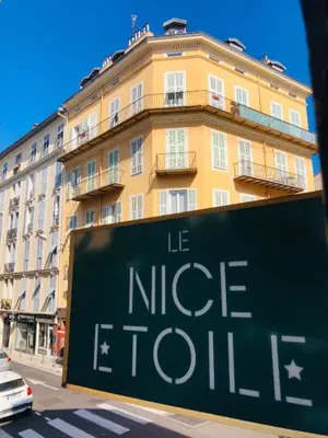 a sign in front of a large building at Hotel le Nice Etoile in Nice