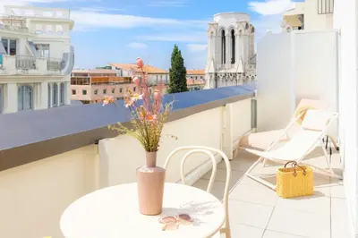 a balcony with a table and a vase with flowers on it at Nice Centre Hotel in Nice