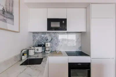 a white kitchen with a sink and a microwave at French Riviera - 3 pièces, vue mer et piscine in Villefranche-sur-Mer