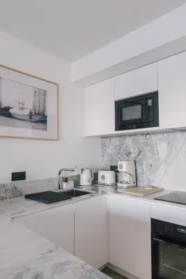 a kitchen with white cabinets and a counter top at French Riviera - 3 pièces, vue mer et piscine in Villefranche-sur-Mer