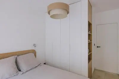 a bedroom with a bed with a lamp and a closet at French Riviera - 3 pièces, vue mer et piscine in Villefranche-sur-Mer