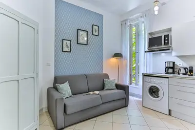 a living room with a couch and a washing machine at MY CASA - GROSSO 14 - 5 min walk to beach in Nice