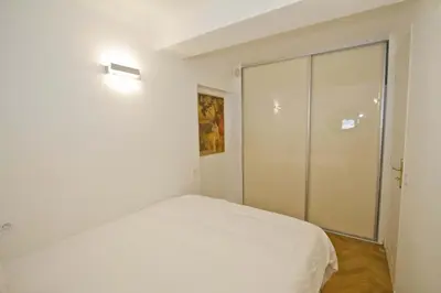 a white bedroom with a bed and a sliding glass door at PROMENADE HOLIDAY - OLD TOWN PANORAMIC in Nice