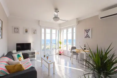a living room with a couch and a table with chairs at #23 Henry IV Vue Panoramique Mer AC & Bright in Nice
