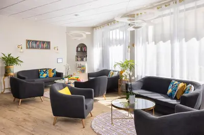 a living room with couches and chairs and a table at Hôtel Locarno Nice in Nice