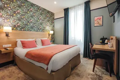 a hotel room with a bed and a desk with a computer at Hôtel de France, un hôtel AMMI in Nice