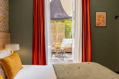 a bedroom with a bed and a door to a patio at Hôtel de France, un hôtel AMMI in Nice