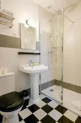 a bathroom with a toilet and a sink and a shower at Hôtel de France, un hôtel AMMI in Nice