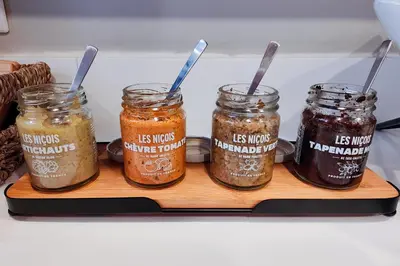 a shelf with four jars of pickles in a refrigerator at Hôtel de France, un hôtel AMMI in Nice