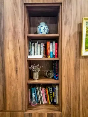 a book shelf with books and a vase on it at Hôtel de France, un hôtel AMMI in Nice