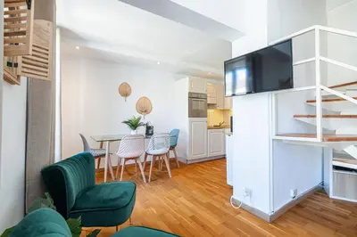 a living room with a couch and a tv at Massena Street - 1 Bdr Duplex with AC & Parking in Nice