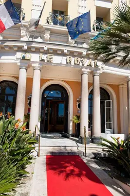a red carpet in front of a building with flags at Hôtel Le Royal Promenade des Anglais in Nice