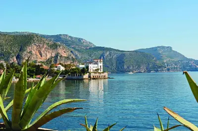 a view of a large body of water with mountains at Hôtel Vacances Bleues Delcloy in Saint-Jean-Cap-Ferrat