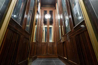 a hallway with wood paneling and a light in a building at Hotel Le Meurice in Nice