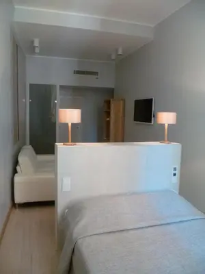 a bedroom with a bed and a couch and a mirror at Hotel Rossetti in Nice