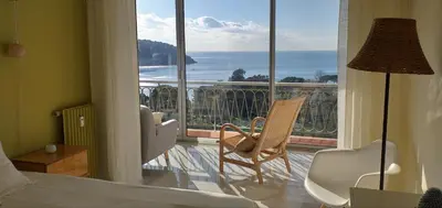 a bedroom with a bed and a balcony with a view at Vue mer exceptionnelle entre Nice et Monaco in Villefranche-sur-Mer