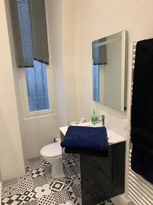 a bathroom with a toilet and a sink and a mirror at Gustave in Nice