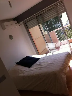 a bedroom with a bed and a large window at La Madonette in Nice
