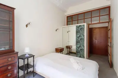a bedroom with a white bed and a wooden door at Appartement Verrière - Welkeys in Nice