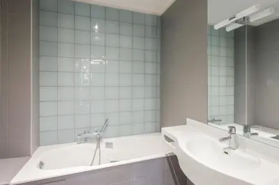 a bathroom with two sinks and a mirror at Appartement Verrière - Welkeys in Nice