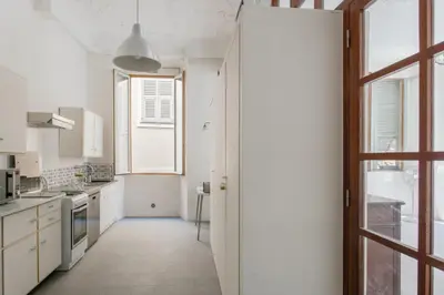 a kitchen with white cabinets and a window at Appartement Verrière - Welkeys in Nice