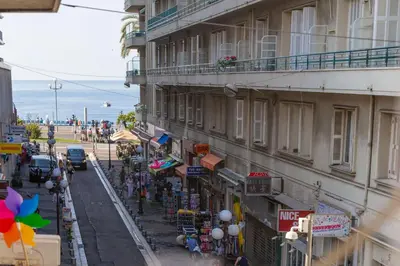 a view of a street with a building and a beach at 100m from the sea in Nice
