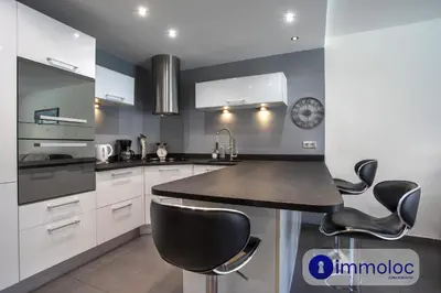a kitchen with white cabinets and a black counter top at Air-conditioned house with private pool in Cagnes-sur-Mer