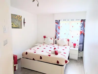 a white bedroom with a bed and a window at La Providence in Nice