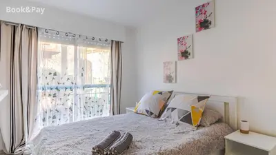 a bedroom with a bed and a large window at La Providence in Nice