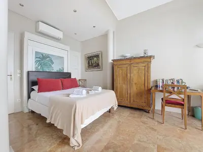 a bedroom with a bed with red pillows and a desk at Nestor&Jeeves - HORIZON PROMENADE - Central - Sea front in Nice
