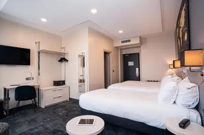 a hotel room with two beds and a tv at Hôtel Univers in Nice