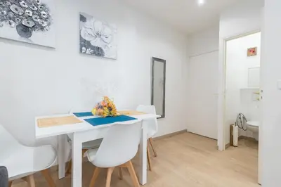 a white dining room with a white table and white chairs at Historical Apartment Hyper Center in Nice