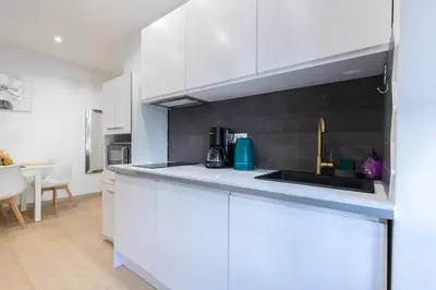 a kitchen with white cabinets and a sink at Historical Apartment Hyper Center in Nice
