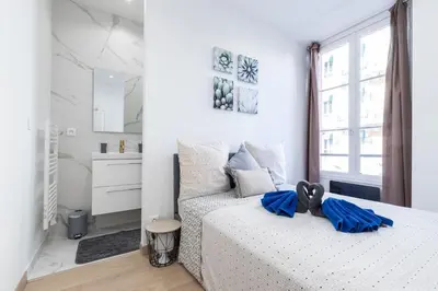 a white bedroom with a bed and a window at Historical Apartment Hyper Center in Nice