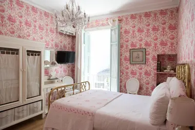 a pink bedroom with a bed and a window at Hotel Villa Rivoli in Nice