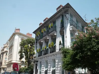 a white building with balconies on a city street at Hotel Villa Rivoli in Nice