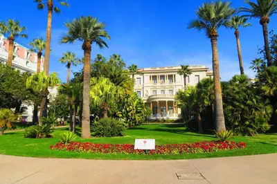 a building with palm trees and a sign in a park at Nestor&Jeeves - DALPOZZO GRANDE - Central - Close beaches in Nice