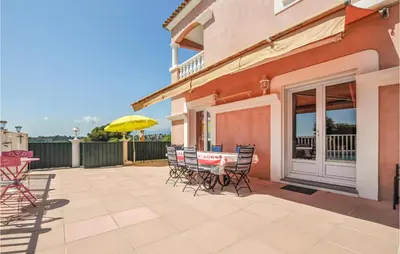 a patio with chairs and a table and an umbrella at Amazing Home In Cagnes Sur Mer in Cagnes-sur-Mer