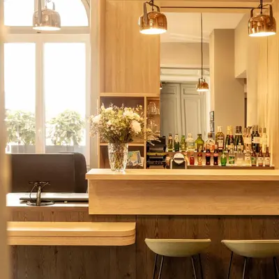 a kitchen with a bar with a vase of flowers at Hôtel Vendôme in Nice