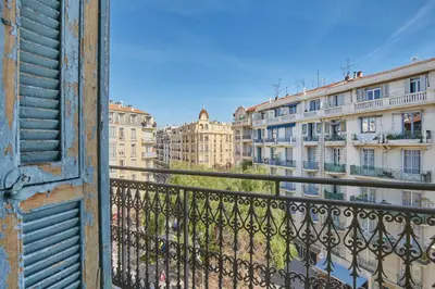 a dining room table with a bottle of wine and a window at Appart'hôtel Odalys City - Nice Centre in Nice