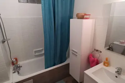 a bathroom with a blue shower curtain and a sink at studio centre nice proche de mer in Nice