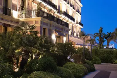 a large building with palm trees in front of it at Hotel Royal-Riviera in Saint-Jean-Cap-Ferrat
